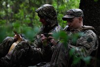 U.S. Army Sgt. Kyle Troyer, a forward observer (left), and Sgt. Kevin Shipley, a team chief with 1st Battalion, 107th Field Artillery, Detachment 1, Maryland Army National Guard, plot grid coordinates during Exercise Hedgehog near Võru, Estonia, May 14, 2025. The State Partnership Program between the Maryland National Guard and Estonia emphasizes civil and military cooperation with civil control of a professional military. Maryland has a key role in this international initiative to foster democracy, encourage market economies and promote regional cooperation and stability. Established in 1993, the Maryland-Estonia partnership serves as a model for future State Partnership Program efforts. (U.S. Army photo by Staff Sgt. Rose Di Trolio)