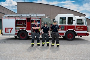 Photo of U.S. Air National Guard civilian firefighters, assigned to the Vermont Air National Guard Fire Department, standing in front of the fire truck that was the first on scene, South Burlington, VT, June 4, 2025. These firefighters provided the first fire truck on scene to a local fire. (U.S. Air National Guard photo by Airman Raymond LaChance)