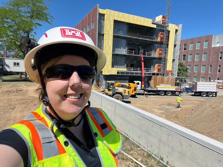 Person poses in front of building exterior.