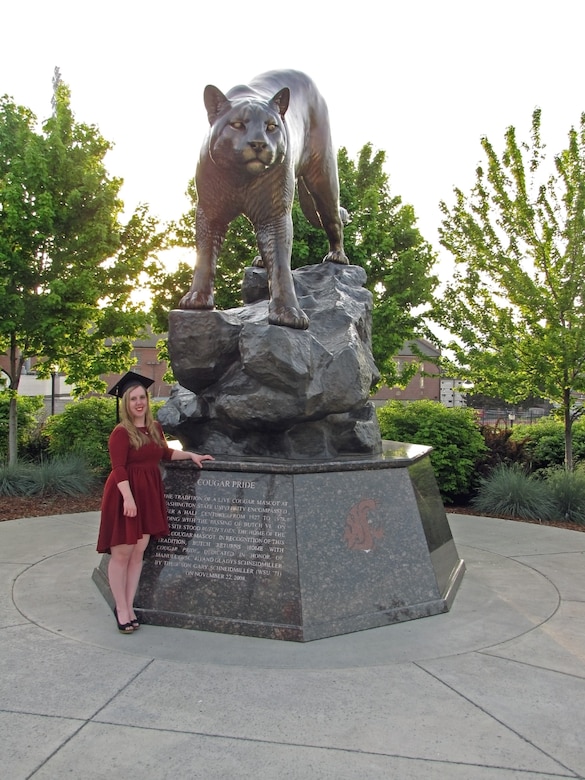 Standing next to cougar statue