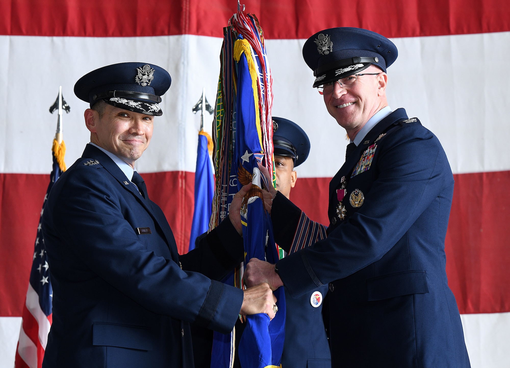 Airmen passes 55th Wing guidon to one another during the 55th Wing change of command ceremony.