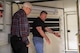 Two men standing in a military shelter.