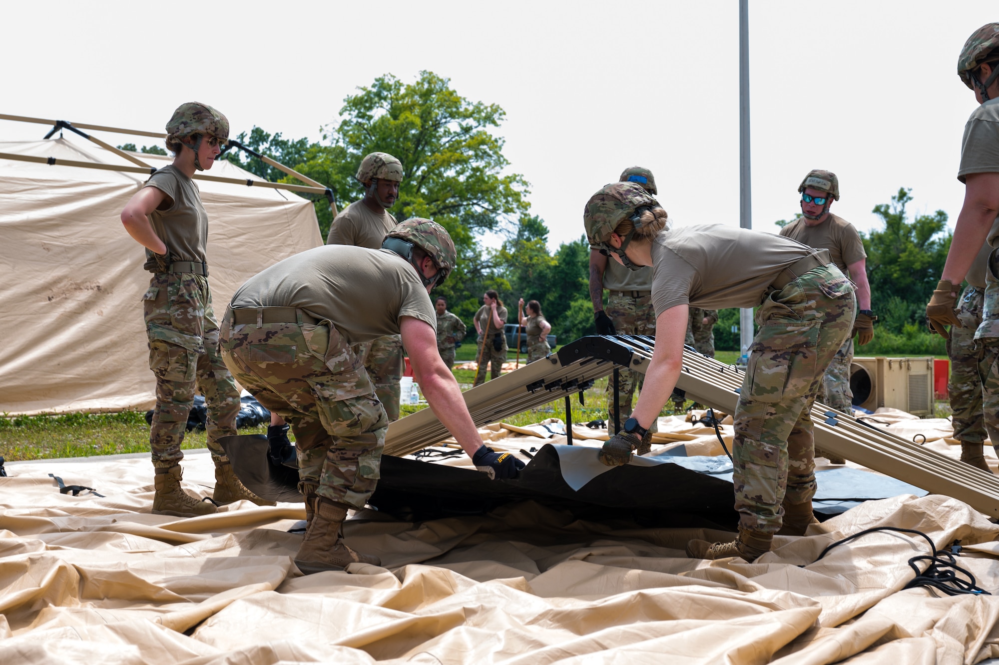 Airmen are outside working together to dismantle camp infrastructure