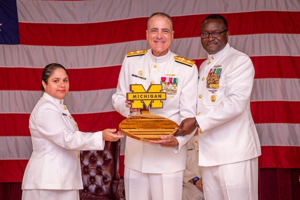 250617-N-KC192-1056 PORTSMOUTH, Va. (June 17, 2025) Chief Religious Programs Specialist Angelique Tulp, assigned to Naval Medical Forces Atlantic (NMFL), and NMFL Command Master Chief Lamar Bethel present Rear Adm. Kevin Brown, former NMFL commander, with a going away gift during a change of command ceremony held on board Hampton Roads - Portsmouth Annex, June 17, 2025. During the ceremony, Brown was relieved by Rear Adm. Robert Hawkins, who will take over as commander, Naval Medical Forces Atlantic and director of Defense Health Network - Atlantic. (U.S. Navy photo by Mass Communication Specialist 2nd Class Levi Decker)