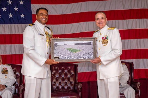 250617-N-KC192-1064 PORTSMOUTH, Va. (June 17, 2025) Lt. Cmdr. Kenneth Bush, the flag aide assigned to Naval Medical Forces Atlantic (NMFL), presents Rear Adm. Kevin Brown, former NMFL commander, with a going away gift during a change of command ceremony held on board Hampton Roads - Portsmouth Annex, June 17, 2025. During the ceremony, Brown was relieved by Rear Adm. Robert Hawkins, who will take over as commander, Naval Medical Forces Atlantic and director of Defense Health Network - Atlantic. (U.S. Navy photo by Mass Communication Specialist 2nd Class Levi Decker)