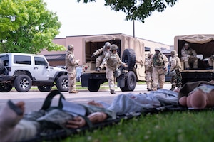 Airmen transport a simulated casualty into a ground vehicle for evacuation during Exercise Cardinal Strike