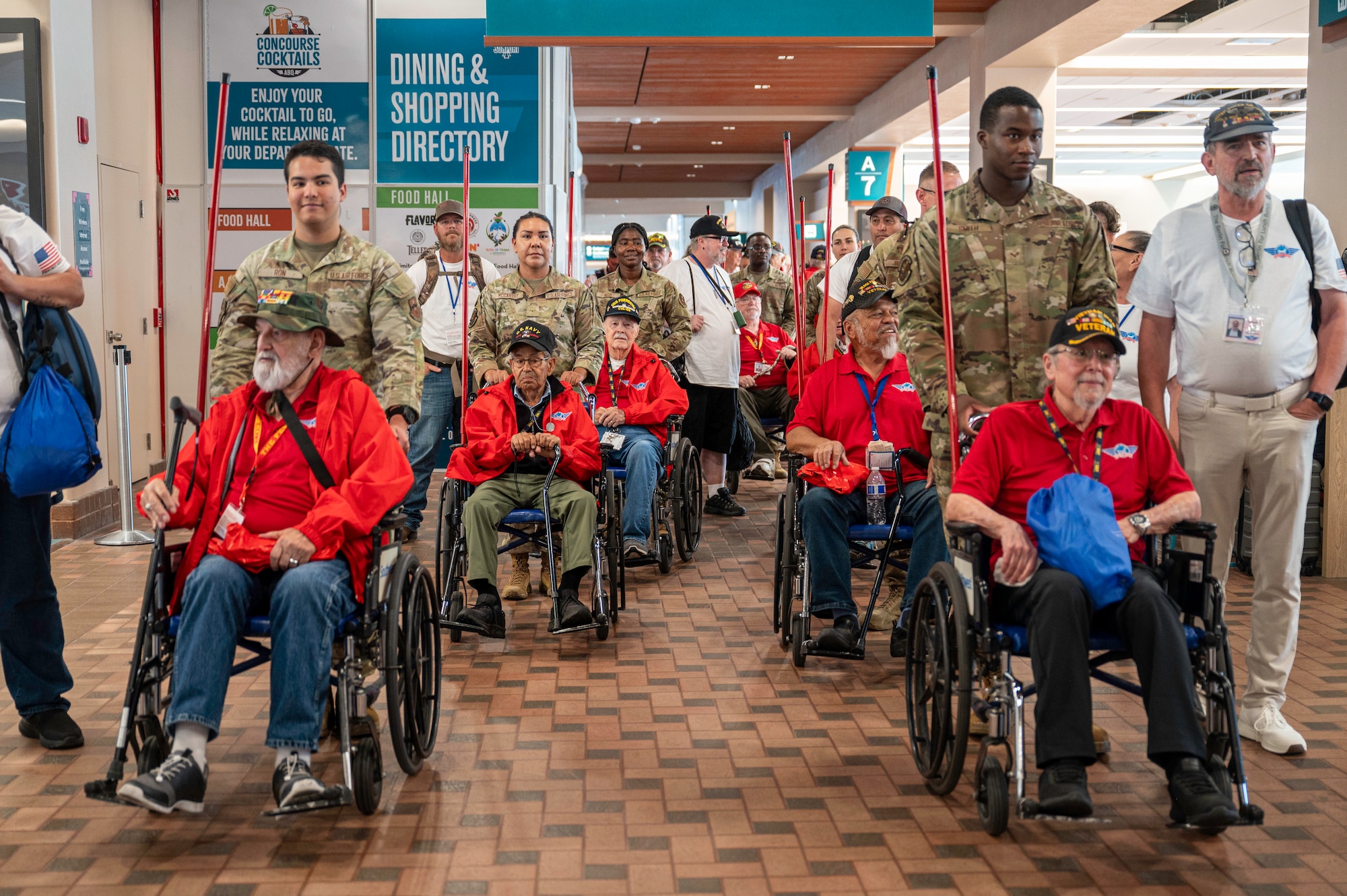 Service members escort veterans through an airport