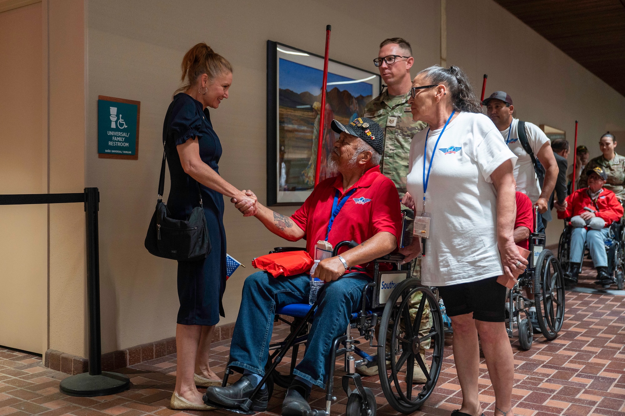 A woman shakes the hand of a veteran.