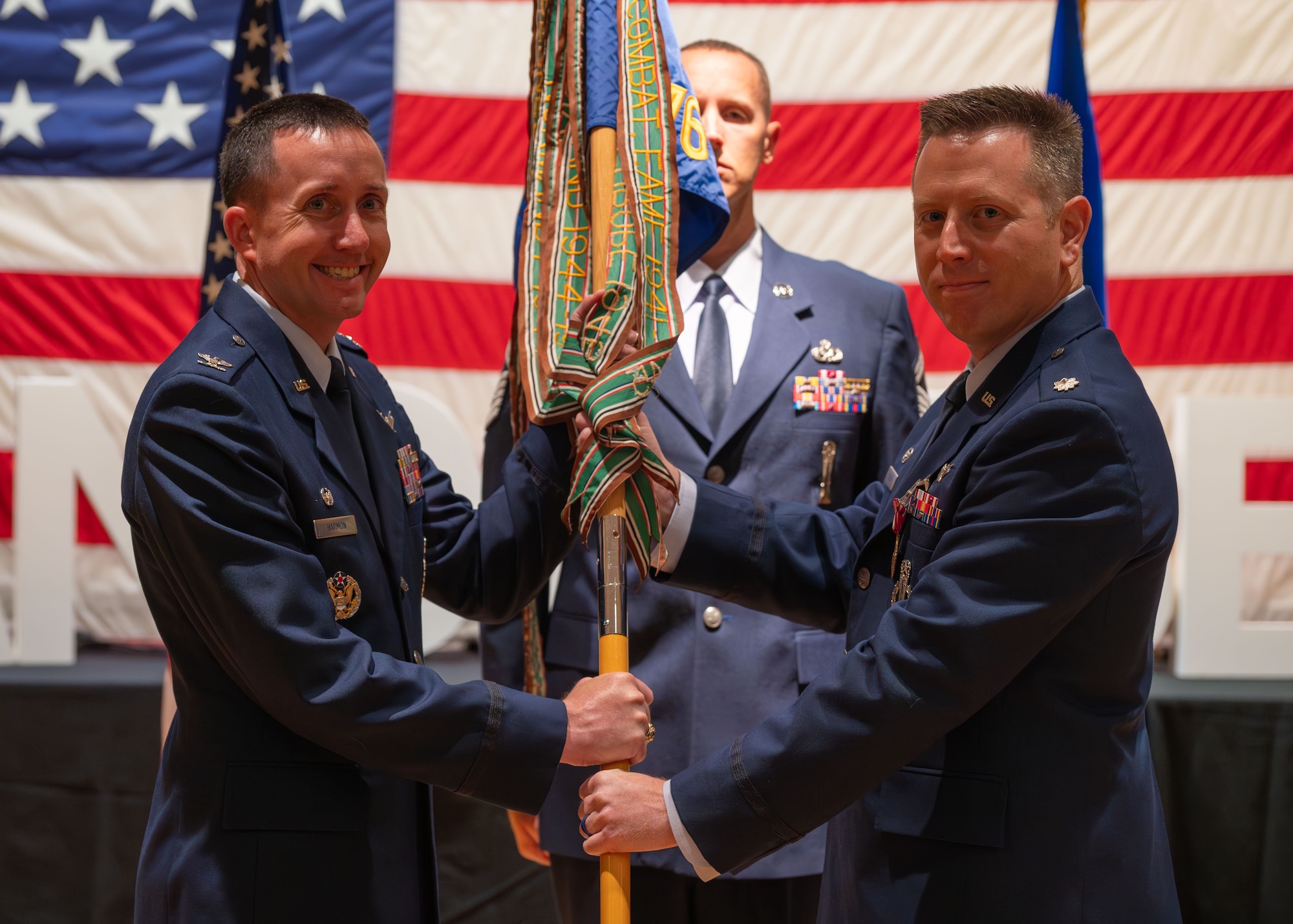 U.S. Air Force Col. Dustin Harmon, 377th Test and Evaluation Group commander, left, receives the guidon from U.S. Air Force Lt. Col. Anthony Santino, outgoing 576th Flight Test Squadron commander during the 576 FLTS change of command ceremony at Vandenberg Space Force Base, Calif., June 17, 2025. Harmon presided over the ceremony, where U.S. Air Force Lt. Col. Anthony Santino relinquished command to Lt. Col. Karrie Wray.