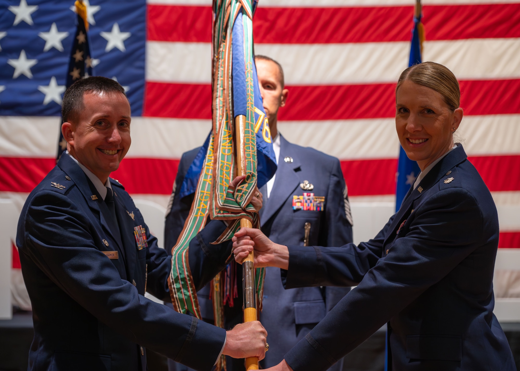 U.S. Air Force Col. Dustin Harmon, 377th Test and Evaluation Group commander, left, passes the guidon from U.S. Air Force Lt. Col. Karrie Wray, incoming 576th Flight Test Squadron commander during the 576 FLTS change of command ceremony at Vandenberg Space Force Base, Calif., June 17, 2025. Harmon presided over the ceremony, where U.S. Air Force Lt. Col. Anthony Santino relinquished command to Wray.