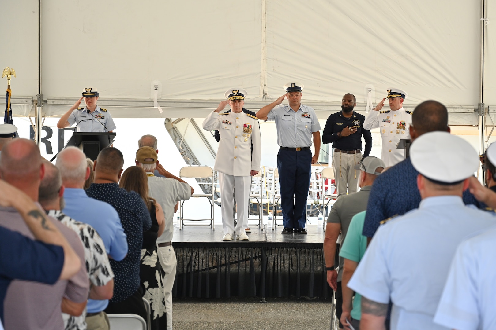 During Coast Guard Cutter Valiant's (WMEC 621) heritage recognition ceremony, the official party and crowd stand for the national anthem in Jacksonville, Florida, June 17, 2024. The cutter was honored after more than 57 years of service in front of Coast Guard and cutter leadership, the assembled crew and former crew members, family and friends. (U.S. Coast Guard photo by Petty Officer 2nd Class Brandon Hillard)