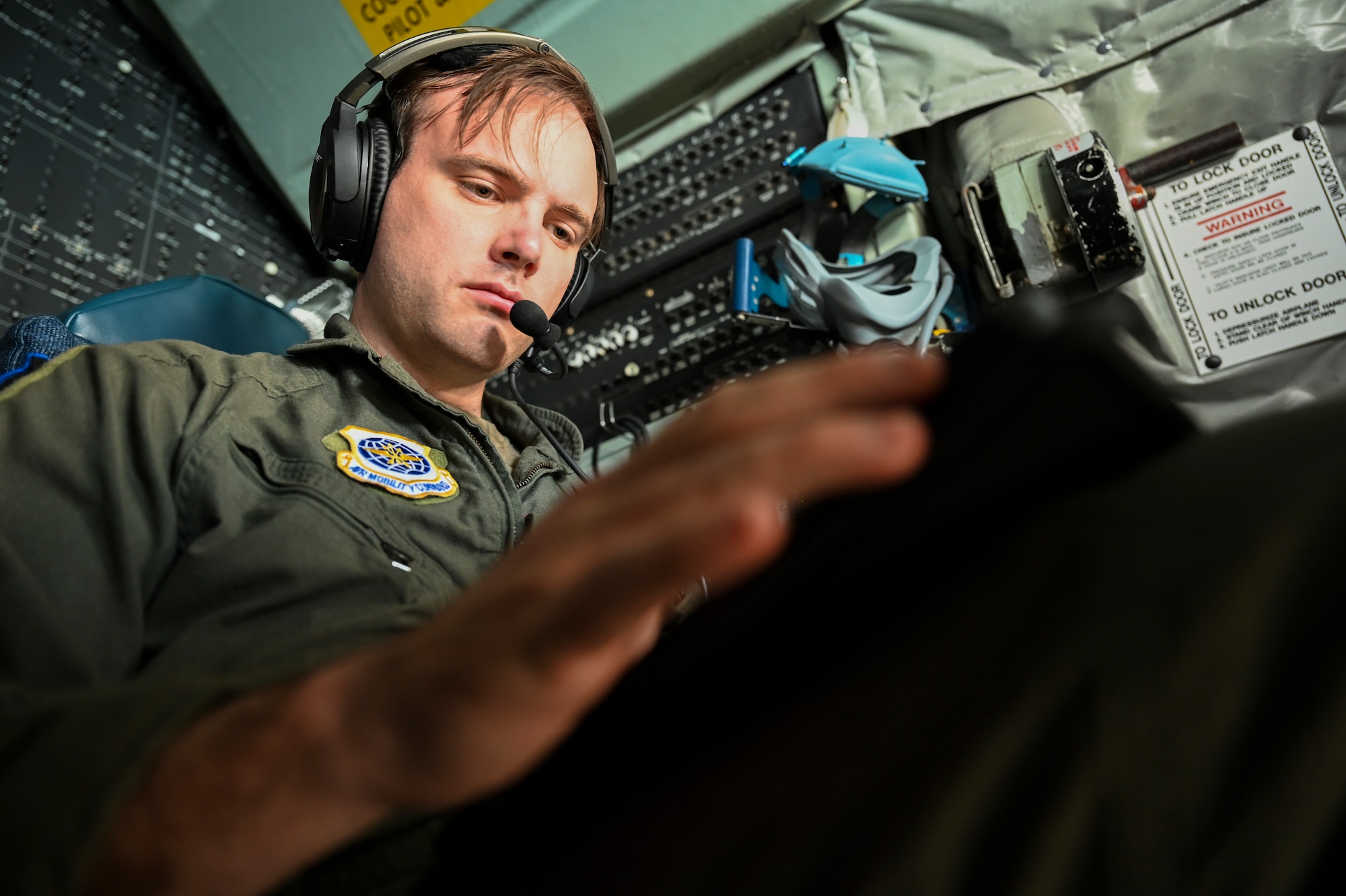 A servicemember sits in the cockpit of a USAF aircraft and prepares for takeoff.