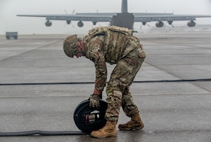 A special operations Airman here rolls out a hose during a Forward Arming and Refueling Point tryout at the 193rd Special Operations Wing June 17, 2025.