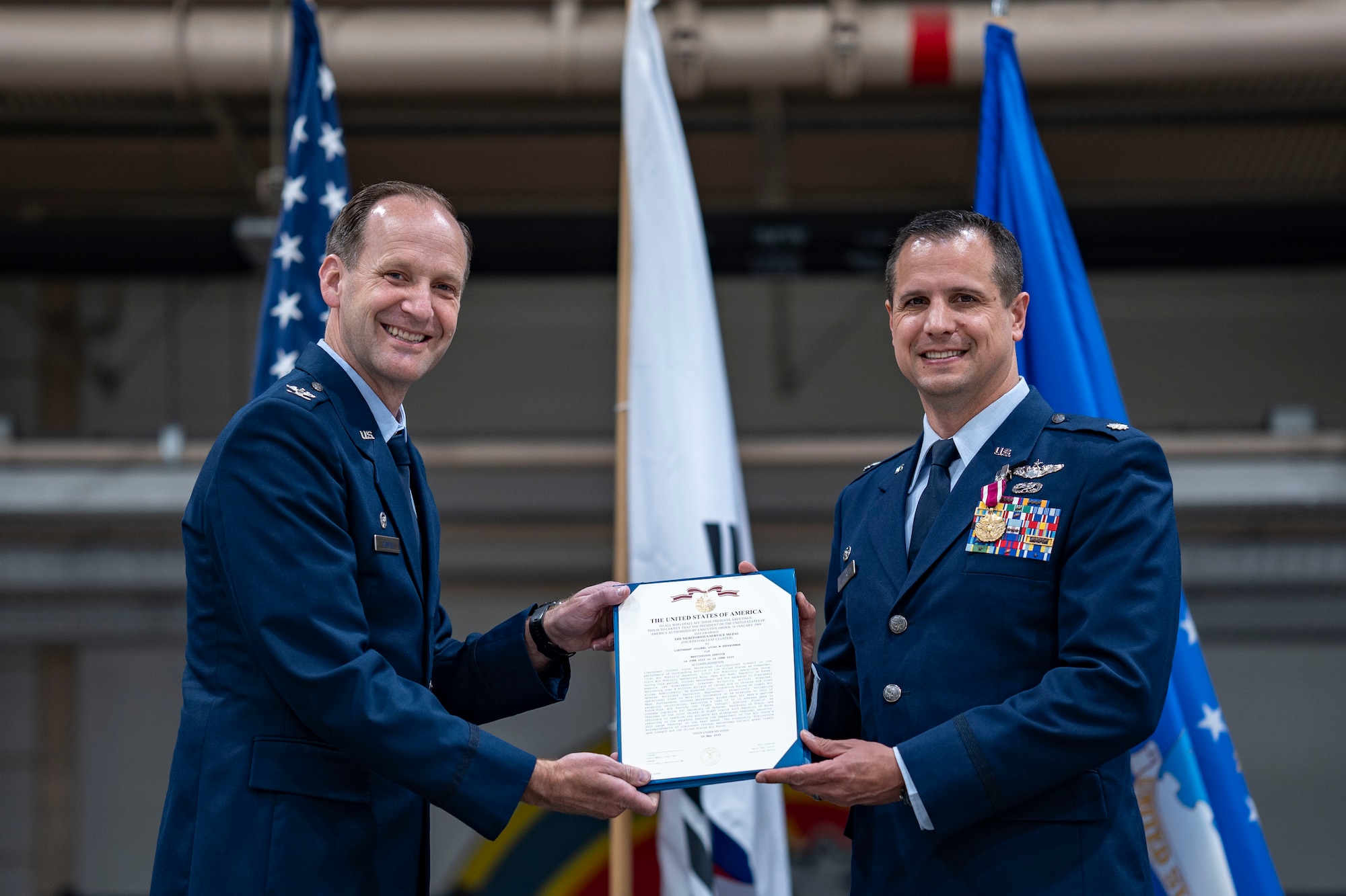 U.S. Air Force Lt. Col. Lucas Berreckman, right, outgoing 731st Air Mobility Squadron commander, right, receives the Meritorious Service Medal from Col. Trigg Randall, left, 515th Air Mobility Operations Group commander, during a Change of Command ceremony at Osan Air Base, Republic of Korea, June 18, 2025.