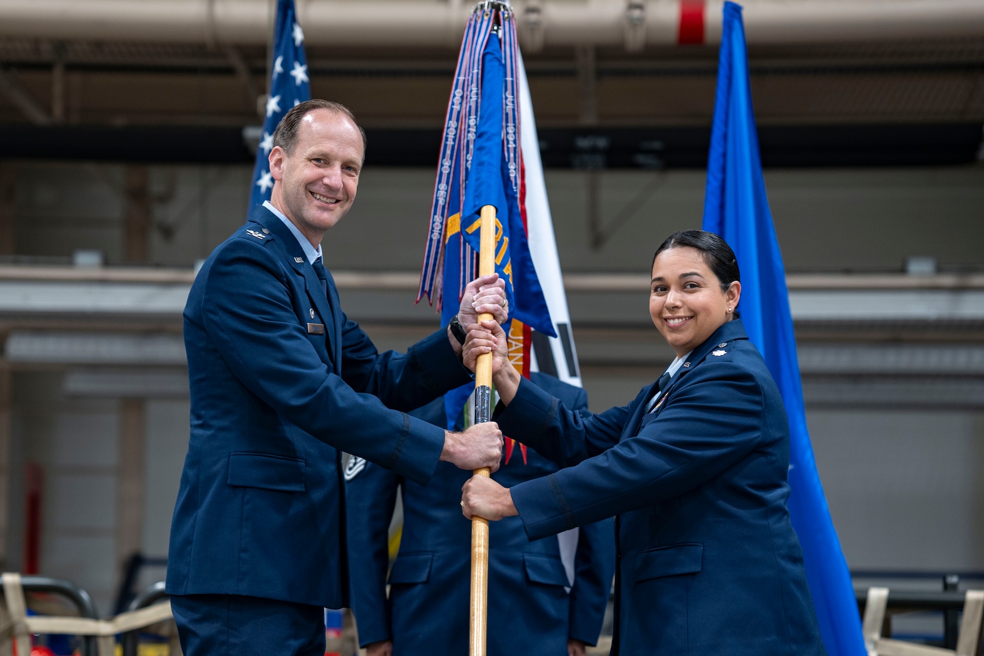 U.S. Air Force Col. Trigg Randall, left, 515th Air Mobility Operations Group commander, passes the guidon to Lt. Col. Diana Halferty, incoming 731st Air Mobility Squadron commander, during a Change of Command ceremony at Osan Air Base, Republic of Korea, June 18, 2025.