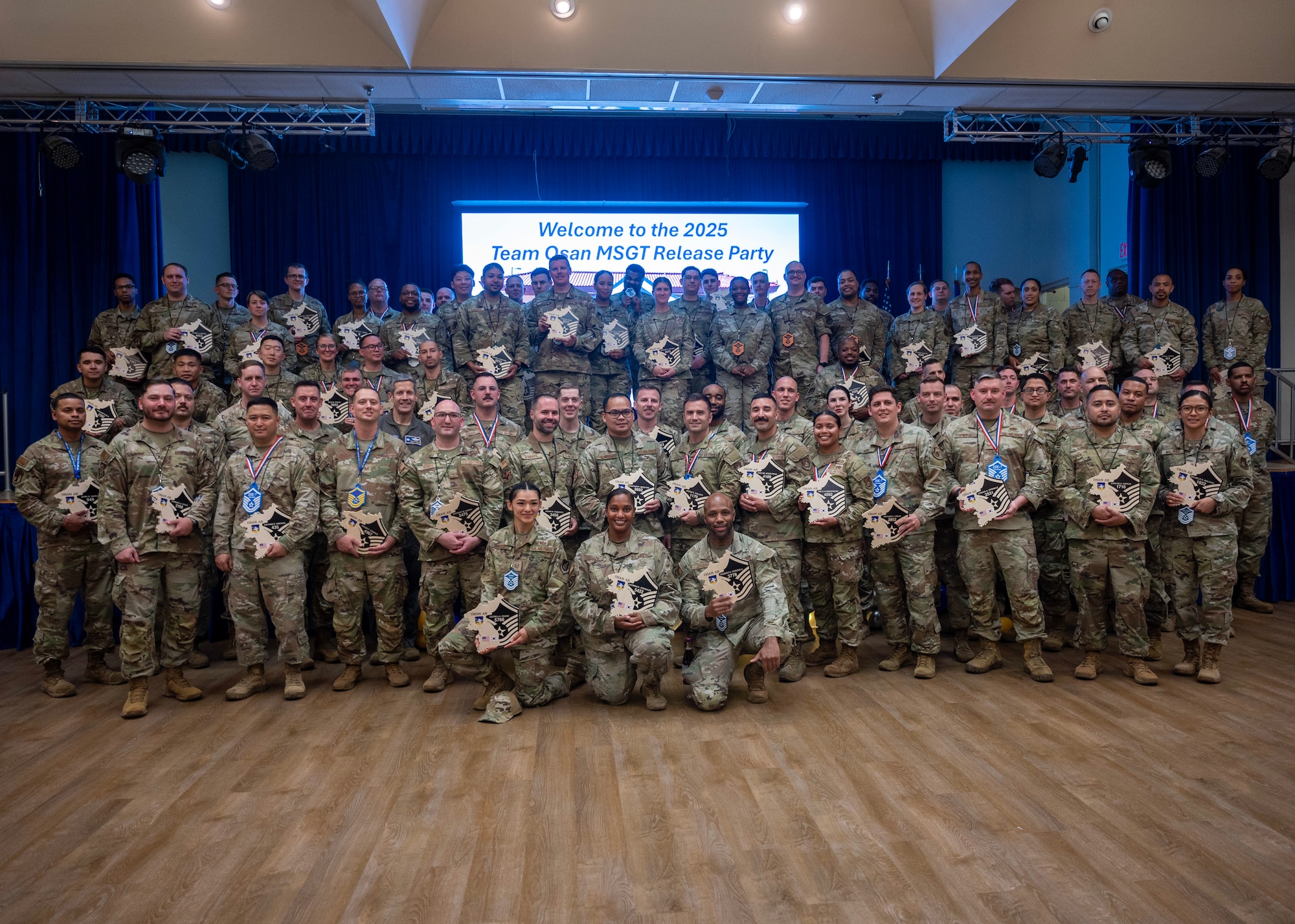 The newest master sergeant selects pose for a group photo during the Master Sergeant Release party at Osan Air Base, Republic of Korea, June 18, 2025. The event recognized their dedication, leadership, and readiness to take on greater responsibilities. (U.S. Air Force photo by Staff Sgt. Sarah Williams)
