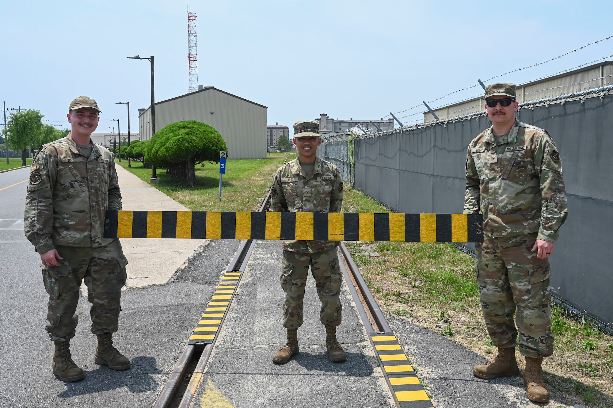 Airman 1st Class Dominic Varoz (left), 8th Maintenance Squadron aircraft metals technology journeyman, Airman 1st Class Jayden Bolo (center), 8th MXS aircraft metals technology journeyman, and Tech. Sgt. Matthew Ebarb (right), 8th MXS noncommissioned officer in charge of aircraft metals technology, show a segment of the custom built railroad track cover their team created at Kunsan Air Base, Republic of Korea, June 17, 2025.