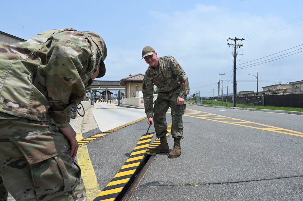 Airman 1st Class Dominic Varoz, 8th Maintenance Squadron aircraft metals technology journeyman, and Airman 1st Class Jayden Bolo, 8th MXS aircraft metals technology journeyman, lift a custom built railroad track cover at Kunsan Air Base, Republic of Korea, June 17, 2025.