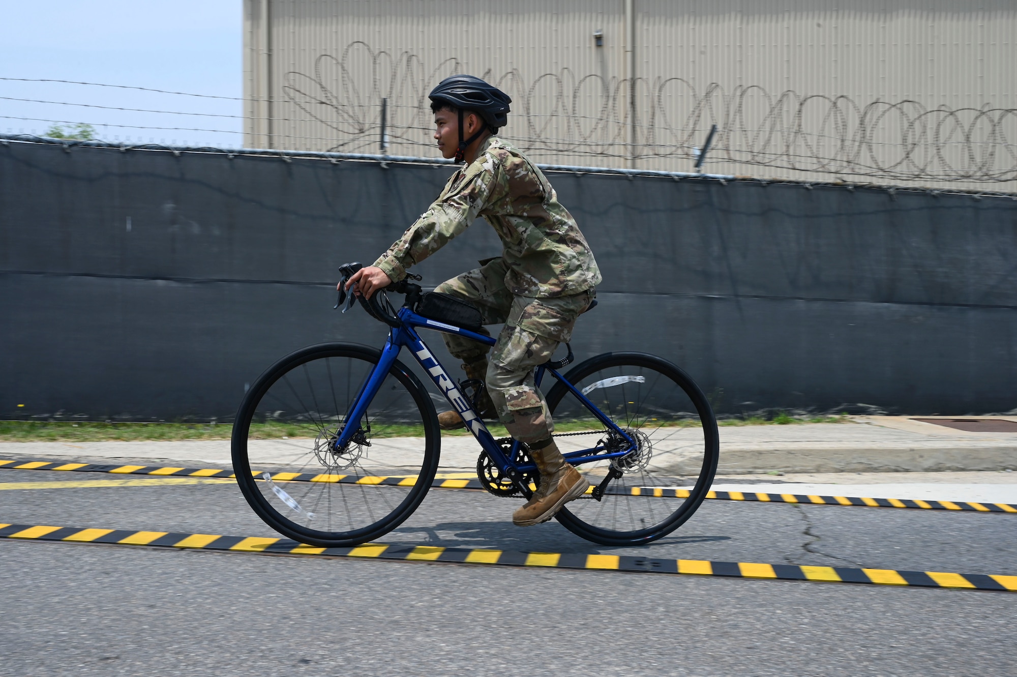 Airman 1st Class Jayden Bolo, 8th Maintenance Squadron aircraft metals technology journeyman, rides a bike over custom built railroad track covers at Kunsan Air Base, Republic of Korea, June 17, 2025.