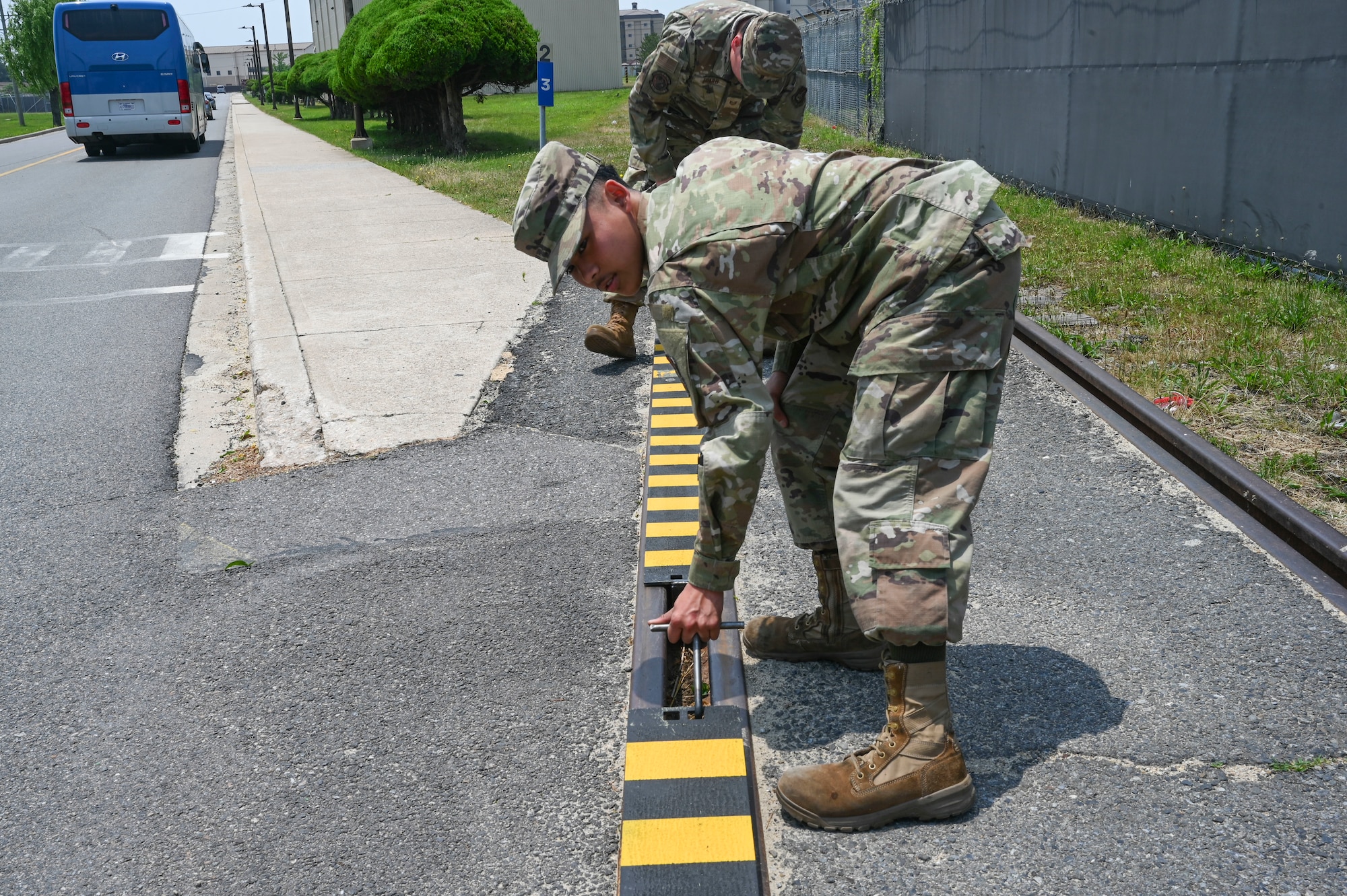 Airman 1st Class Jayden Bolo, 8th Maintenance Squadron aircraft metals technology journeyman, uses a specially fabricated hook to install a custom built railroad track cover they created at Kunsan Air Base, Republic of Korea, June 17, 2025.