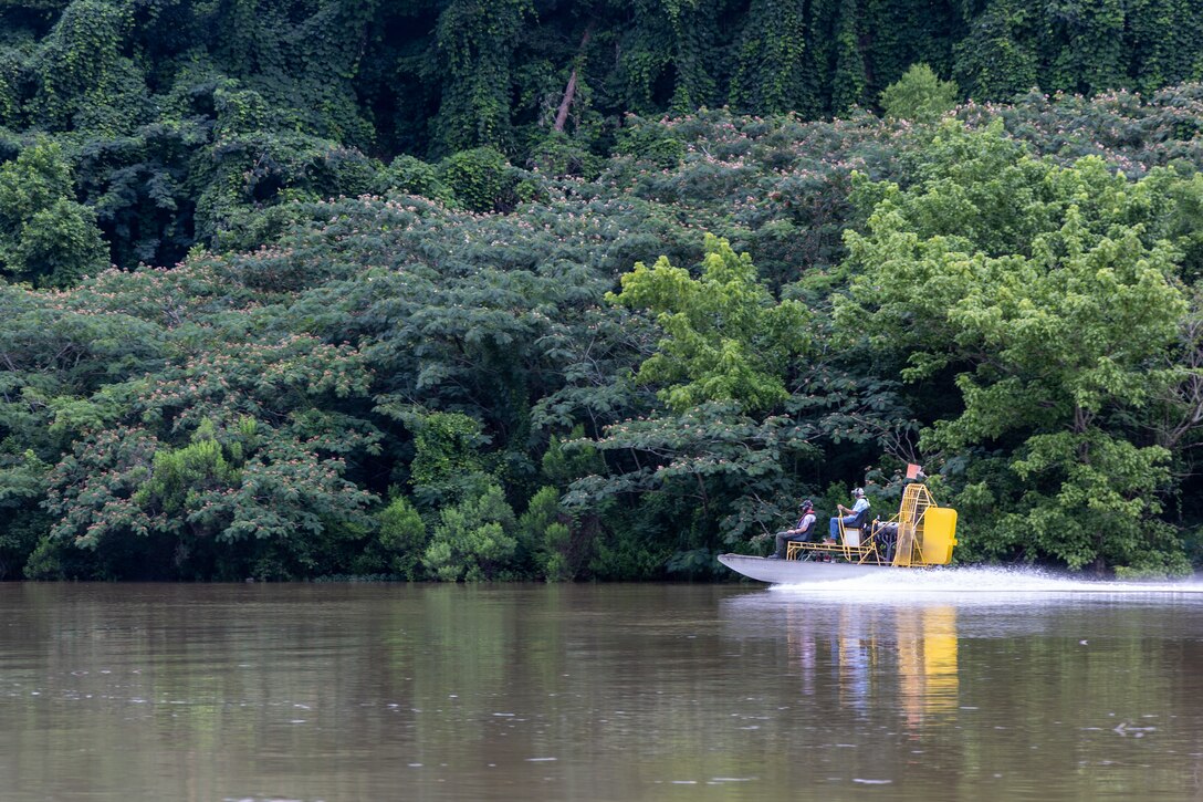 Picture of two men riding an airboat.