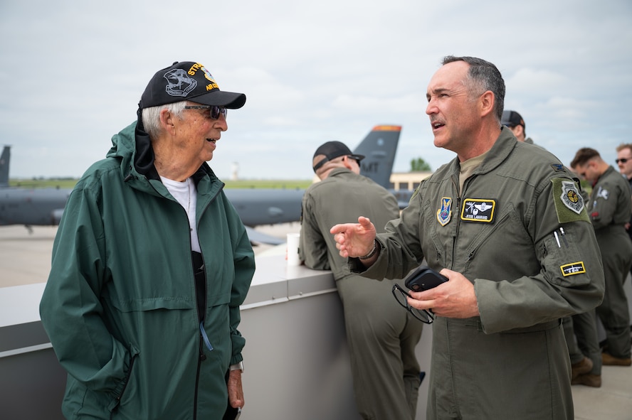 Gary Lee speaks with Col. Jesse Lamarand on a rooftop. B-52H Stratofortress aircraft is visible in the background.
