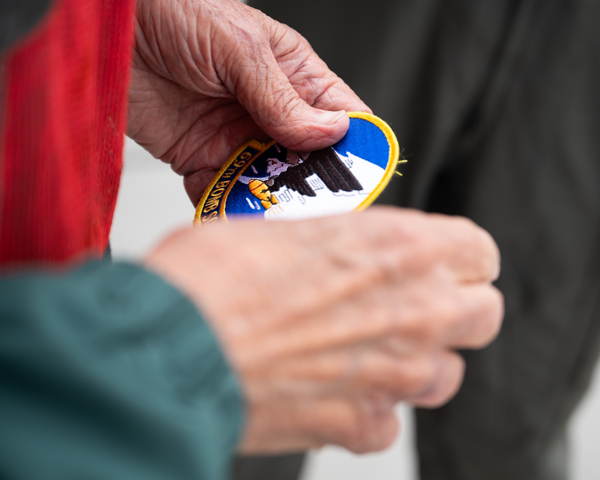 Gary Lee holding a 69th Bomb Squadron patch.