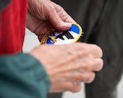 Gary Lee holding a 69th Bomb Squadron patch.
