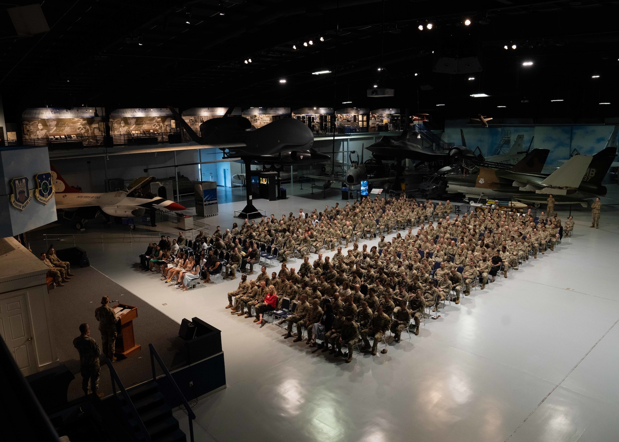 A top shot photo of a large group of military personnel sitting in chairs