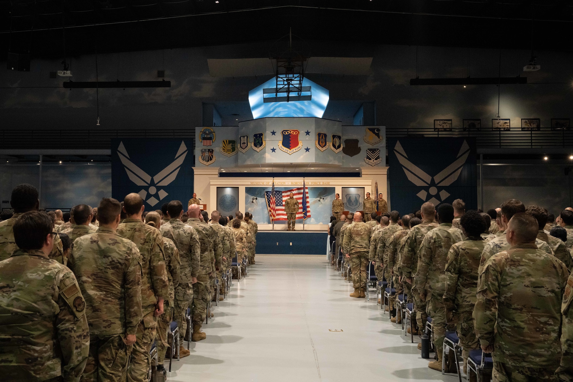 A group of military people standing while looking at a stage