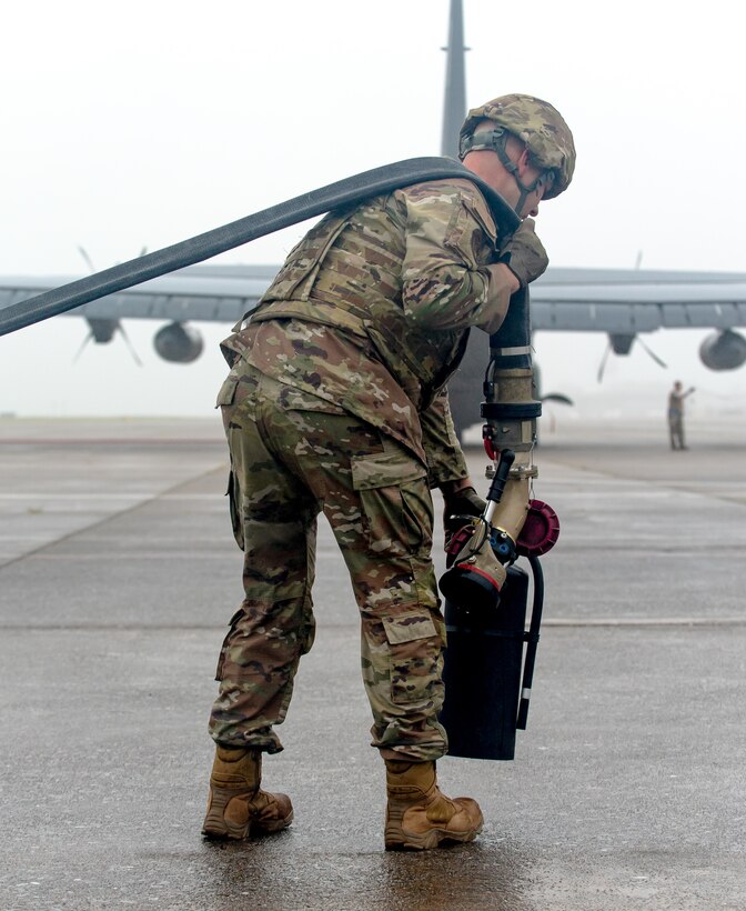 A special operations refueler here carries a hose and fire extinguisher during a Forward Arming and Refueling Point tryout at the 193rd Special Operations Wing June 17, 2025.
