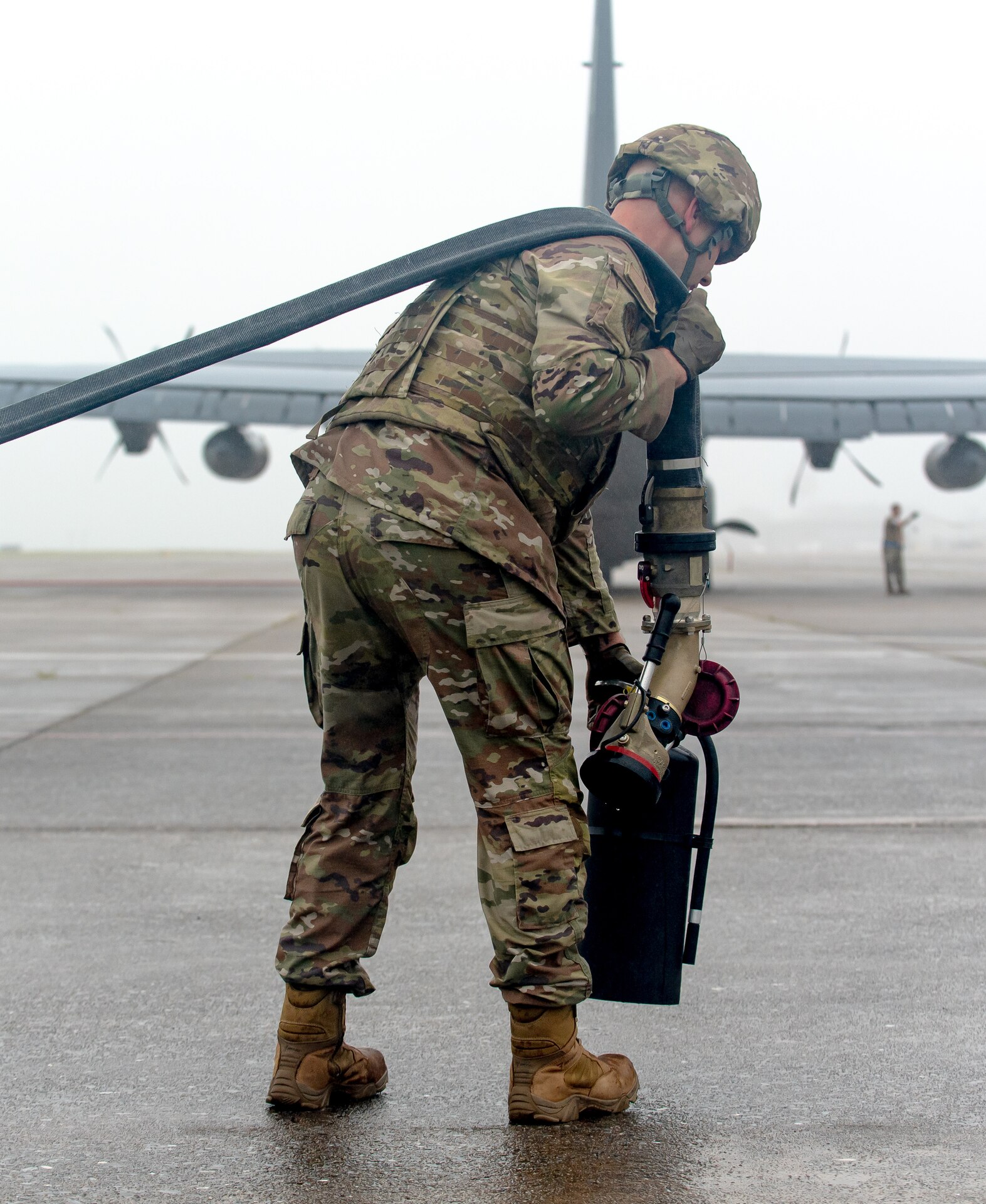 A special operations refueler here carries a hose and fire extinguisher during a Forward Arming and Refueling Point tryout at the 193rd Special Operations Wing June 17, 2025.