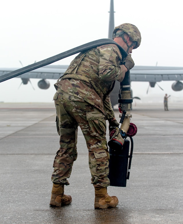 A special operations refueler here carries a hose and fire extinguisher during a Forward Arming and Refueling Point tryout at the 193rd Special Operations Wing June 17, 2025.