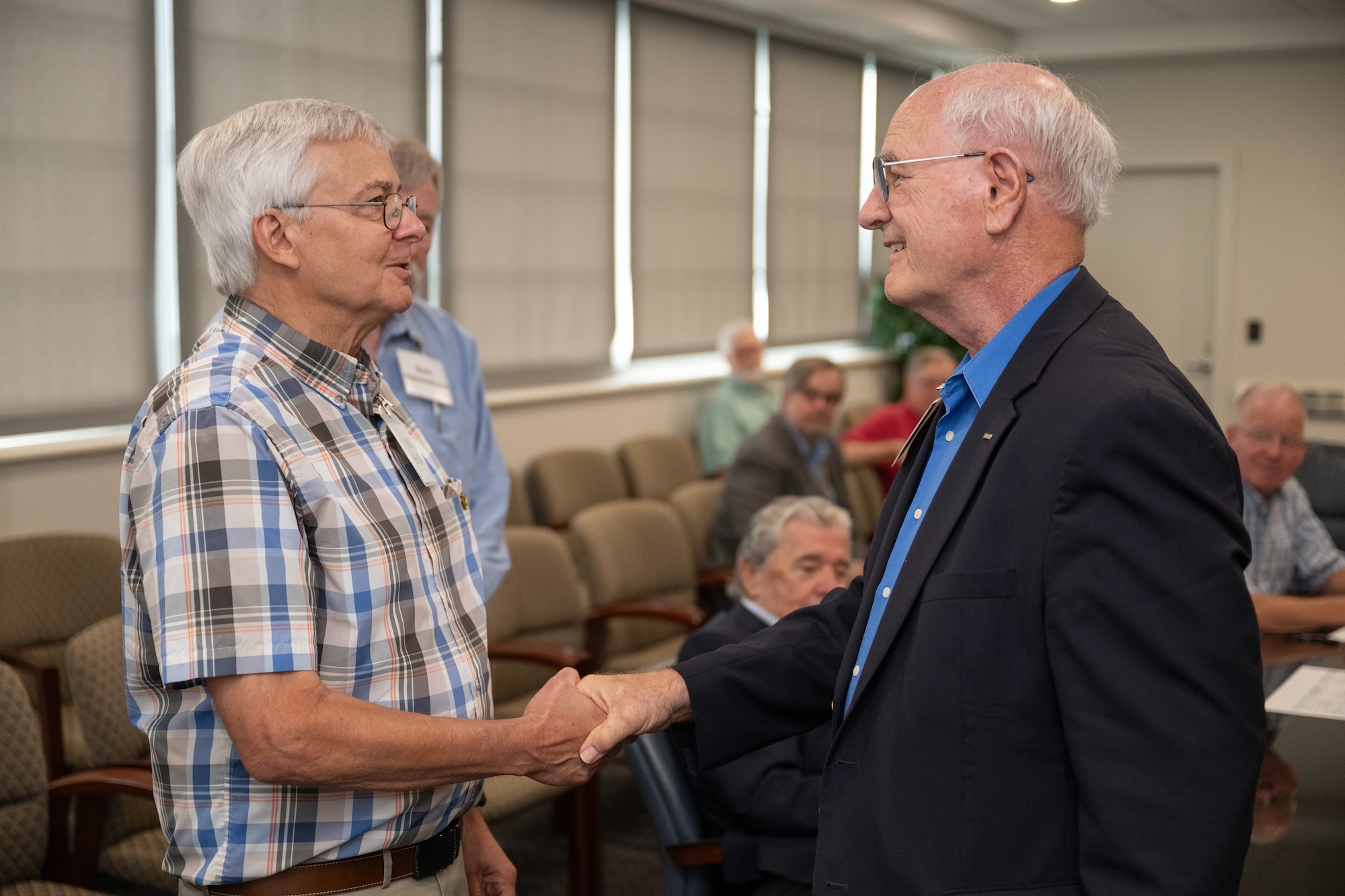 Newly selected Arnold Engineering Development Complex Fellow Bill Phillips, left, shakes hands with Maj. Gen. (Ret.) Mike Wiedemer with the Arnold Community Council after receiving his AEDC Fellows lapel pin from during AEDC Fellows Day June 17, 2025, at Arnold Air Force Base, Tenn. AEDC is headquartered at Arnold AFB. Phillips was one of the three AEDC retirees selected by the ACC for induction into the Fellows program this year. The AEDC Fellows program recognizes AEDC personnel who have made substantial and exceptionally distinguished contributions to the nation’s aerospace ground testing capability. Newly selected AEDC Fellows are traditionally honored annually on or around June 25 to coincide with the birthday of Gen. Henry “Hap” Arnold and anniversary of the June 1951 dedication of AEDC in Gen. Arnold’s honor. (U.S. Air Force photo by Keith Thornburgh)