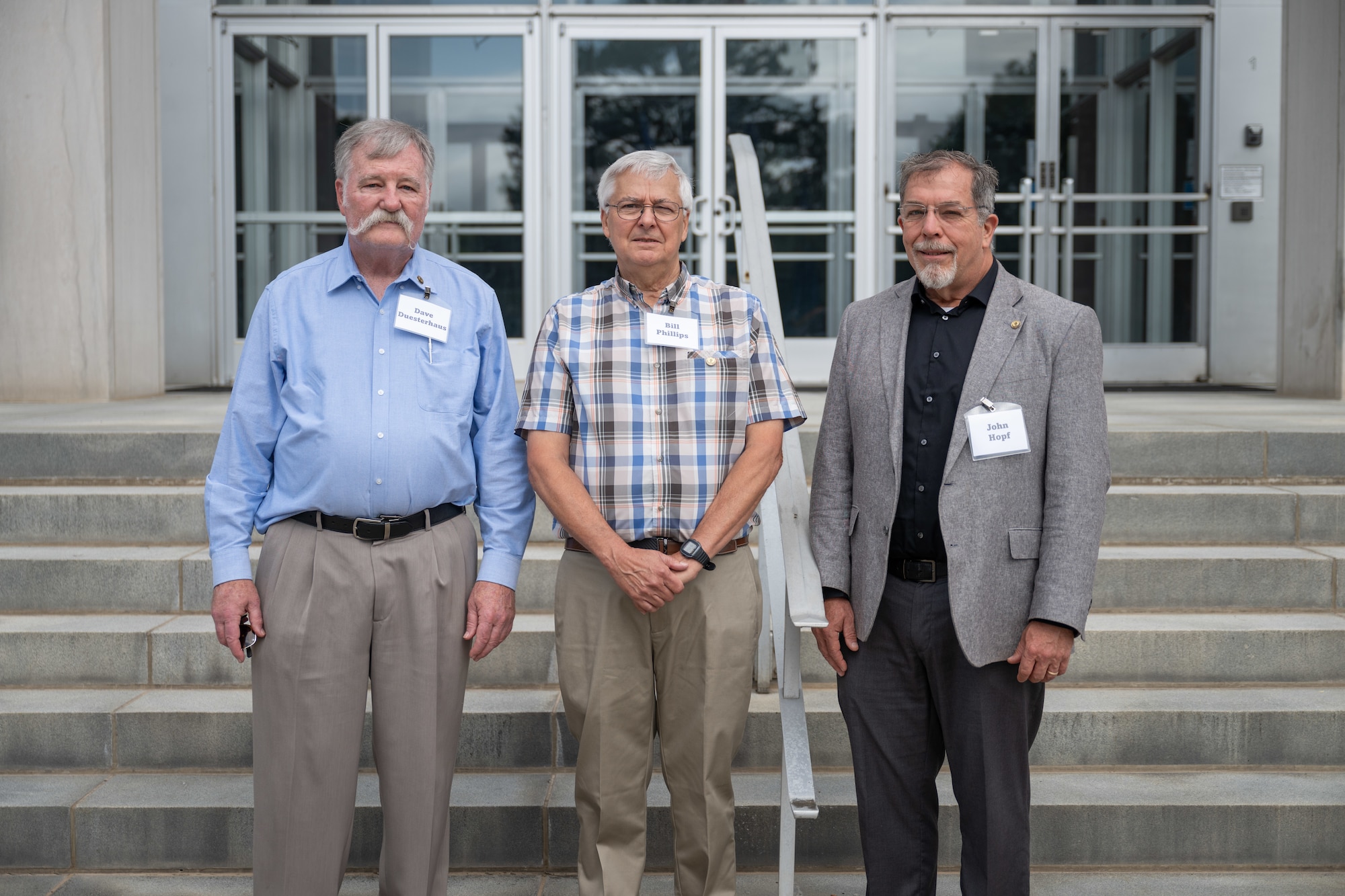 The trio of newly selected Arnold Engineering Development Complex Fellows pose for a photo in front of the Administration and Engineering Building at Arnold Air Force Base, Tenn., during AEDC Fellows Day, June 17, 2025. AEDC is headquartered at Arnold AFB. Pictured from left are Dave Duesterhaus, Bill Phillips and John Hopf. The AEDC Fellows program recognizes AEDC personnel who have made substantial and exceptionally distinguished contributions to the nation’s aerospace ground testing capability. Newly selected AEDC Fellows are traditionally honored annually on or around June 25 to coincide with the birthday of Gen. Henry “Hap” Arnold and anniversary of the June 1951 dedication of AEDC in Gen. Arnold’s honor. (U.S. Air Force photo by Keith Thornburgh)
