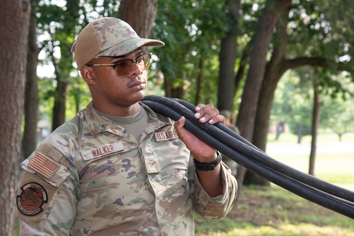 U.S. Air Force Airman 1st Class Andrew E. Walker, 316th Civil Engineer Squadron electrical power production shop, moves power cables for a mobile generator outside the Tactical Fitness Center at Joint Base Andrews, Md. Airmen from the 316th CES set up auxiliary power and air conditioning units for U.S. Army Soldiers staying at the fitness center prior to the Army’s 250th Birthday Festival and Parade June 14 in Washington, D.C.