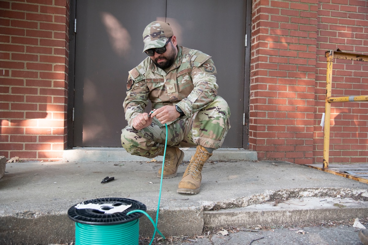 U.S. Air Force Staff Sgt. Jorge Cruz Montero, 316th Civil Engineer Squadron electrical power production supervisor, strips insulation from a ground wire for a mobile generator at the Tactic Fitness Center at Joint Base Andrews, Md., June 11, 2025. Both fitness centers and the Community Commons were transformed into living quarters for about 250 Soldiers supporting in the Army’s 250th Birthday Festival and Parade held June 14 in Washington, D.C.