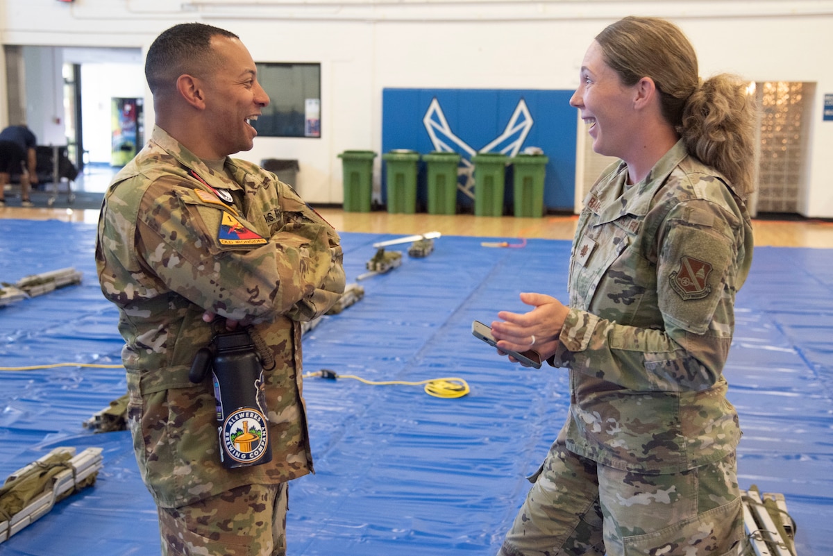U.S. Army Sgt. 1st Class Derek V. Edmonds, 82nd Combat Aviation Brigade, speaks with U.S. Air Force Maj. Allison W. Rayome, 316th Force Support Squadron, at Joint Base Andrews, Md., June 11, 2025. Thanks to joint efforts by Army and Air Force personnel, more than 250 Soldiers settled into the fitness centers and Community Commons at Andrews ahead of participation in the Army’s 250th birthday celebration in Washington, D.C.