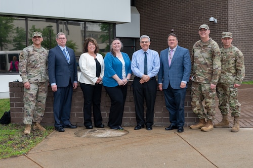 Image of people posing for a group photo in front of building.