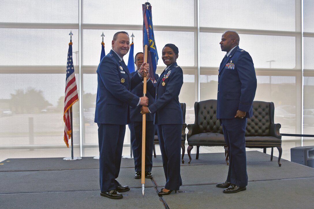 Outgoing 82d Medical Group commander, Col. Sarah Evans, hands the guidon to 82d Training Wing Commander Brig. Gen. Paul Filcek