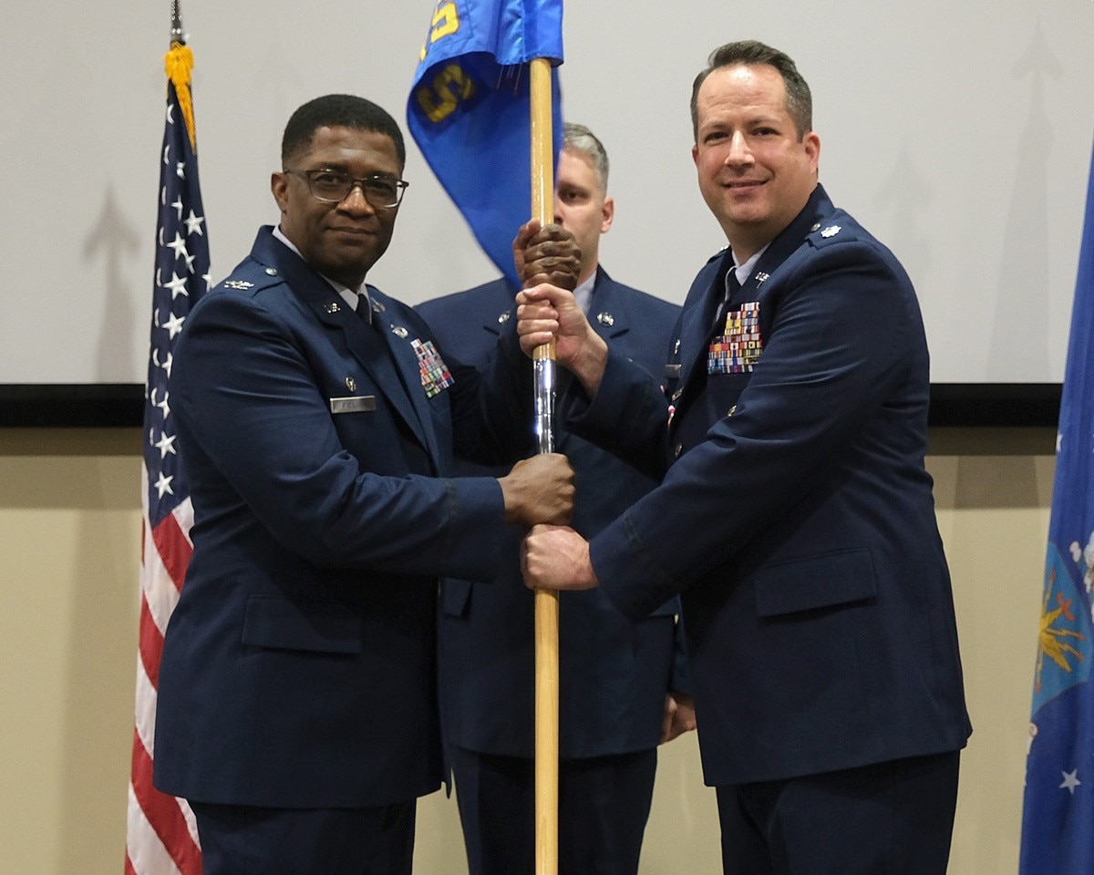 photo of US Airmen holding a unit flag