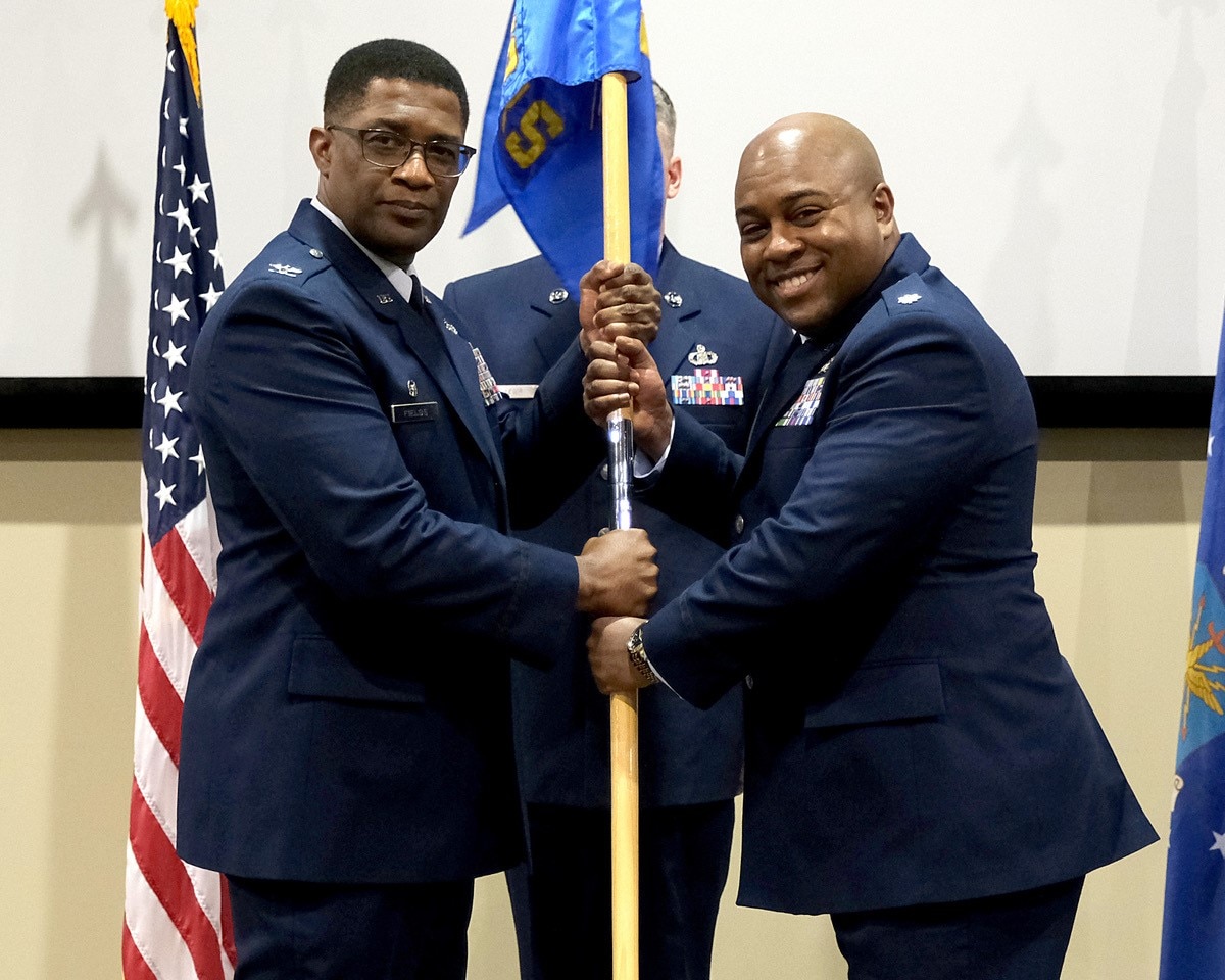 photo of US Airmen holding a unit flag