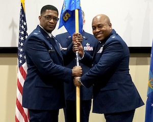photo of US Airmen holding a unit flag
