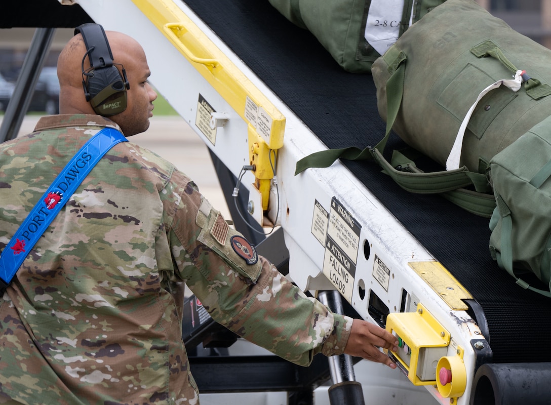Airman assigned to the 89th Aerial Port Squadron operates a luggage conveyor.