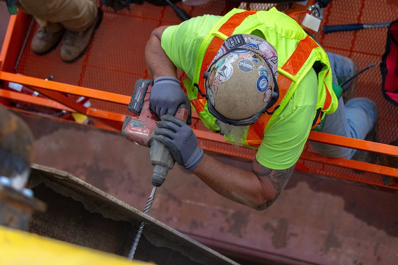 Construction crews work at a navigational lock along a river.
