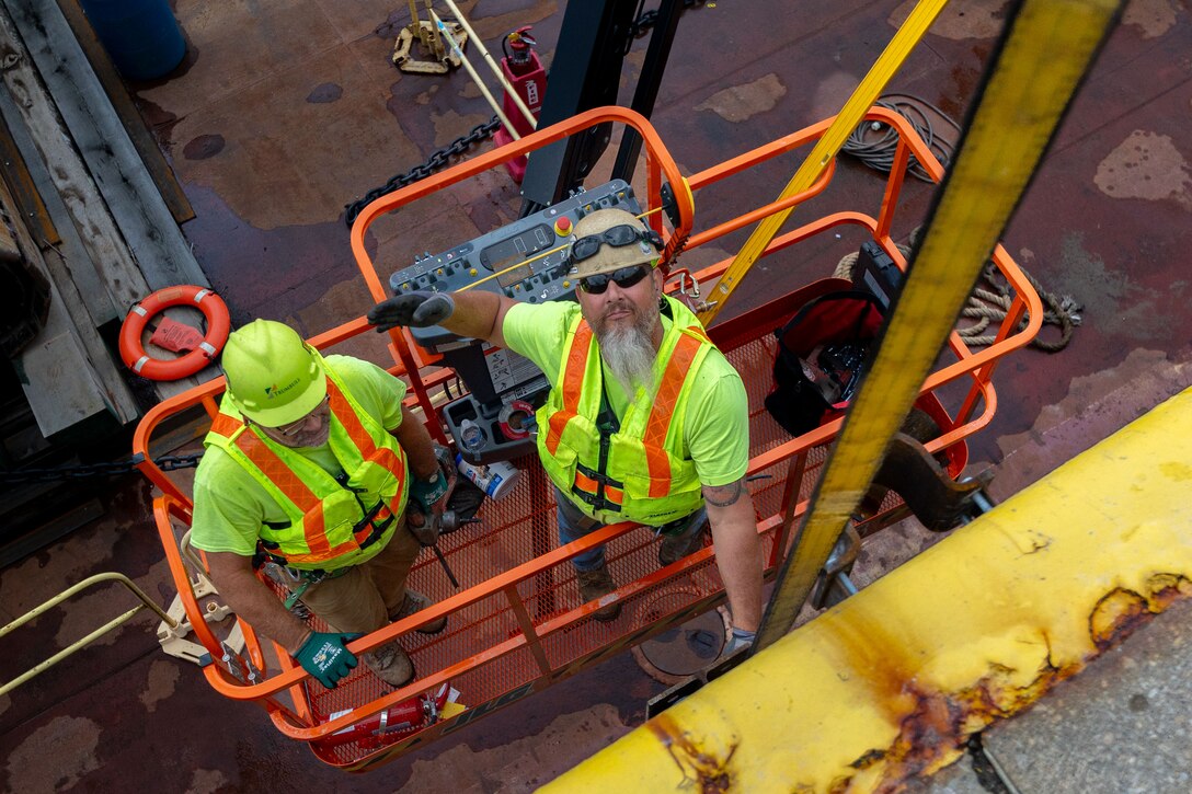 Construction crews work at a navigational lock along a river.