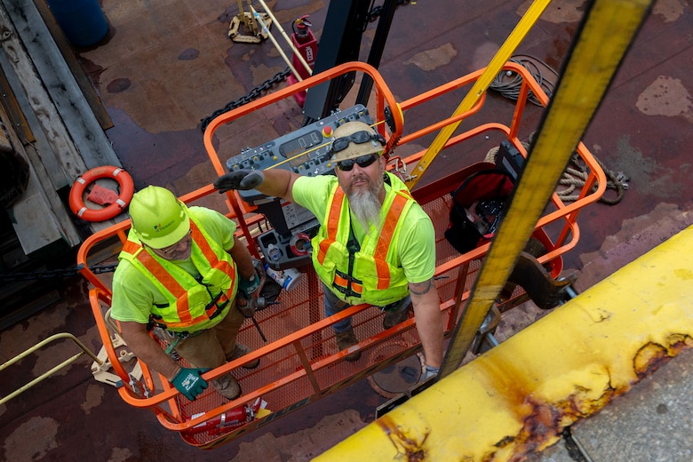 Construction crews work at a navigational lock along a river.