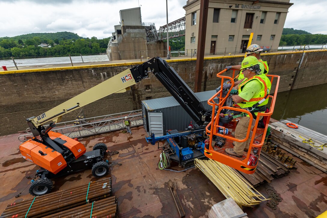 Construction crews work at a navigational lock along a river.