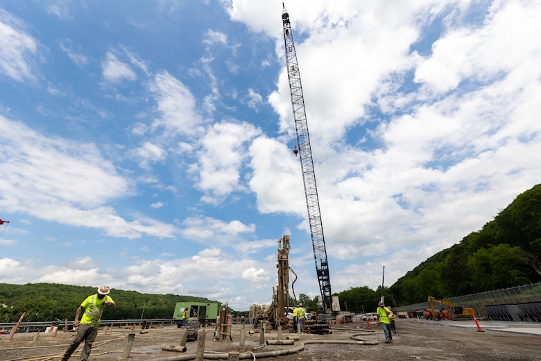 Construction workers make groundbreaking progress at a construction site at a navigational lock along a river.