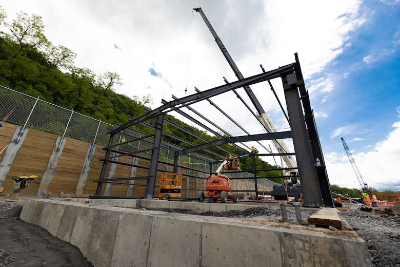 Construction workers make groundbreaking progress at a construction site at a navigational lock along a river.